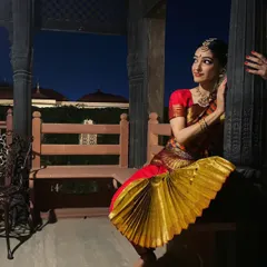 A classic Bharatanatyam pose captured during a performance. The fan-like pleats of the costume and the specific hand gesture, or mudra, are essential elements of this traditional Indian dance form.