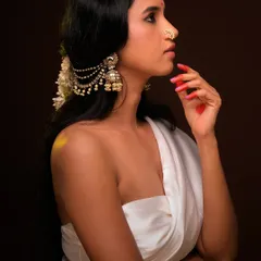 A side profile from the same series, this shot emphasizes the beautiful hair accessory and the elegant line of the model's neck. The lighting creates a soft glow on her skin.