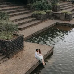 An intimate moment by the water's edge at a serene ghat-style location. This high-angle shot creates a sense of peace and seclusion within the bustling city.