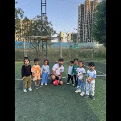 A proud moment for our youngest group, posing with their coach. We create a supportive atmosphere where even the smallest players feel like champions.