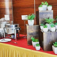 A close up of the decor for a corporate buffet, using minimalist wooden blocks and small plants. This adds a touch of sophistication without being distracting.