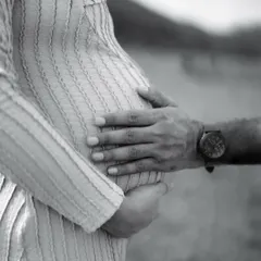 A beautiful black and white close-up of both parents' hands cradling the baby bump. This image is a powerful symbol of their shared love and protection.