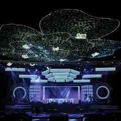 The main stage and ceiling installation for the 'Neon Love' Sangeet. The massive, illuminated floral-shaped structures and LED screens created a stunning, high-tech canopy for the performances.