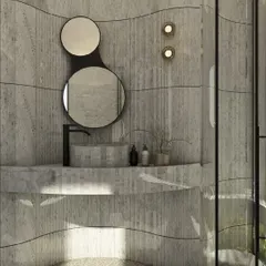 A detail of the curved marble bathroom, showing the custom vanity and the organically shaped double mirrors. The design uses flowing lines and natural materials to create a serene and immersive ambiance.