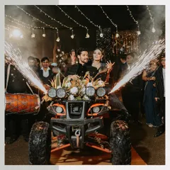Making an unforgettable entrance on an ATV. This shot captures the couple's bold and fun personality during their Sangeet night, complete with dhol players and sparklers.