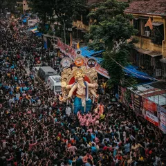 An aerial drone shot showing the massive crowd accompanying the idol through the streets of Chinchpokli. This perspective highlights the sheer scale of the festival.