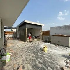 This is a work-in-progress shot of a large rooftop project. You can see the new flooring being laid and the basic structure for a covered seating area taking shape. This is where the vision starts becoming a reality.