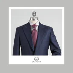 A close-up view of the navy suit, paired with a patterned shirt and a rich burgundy tie, showcasing how our suits serve as a perfect canvas for personal styling.