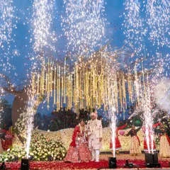 Under a sky lit by fireworks, this couple exchanged garlands beneath a custom-designed 'tree of life' mandap. This spectacular Varmala moment at a Lonavala resort combined rustic charm with explosive celebration, a perfect reflection of their vibrant love story.