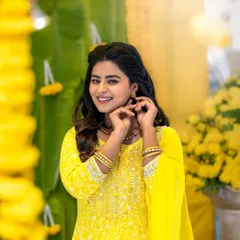 Actress Inchara Joshi looking bright and cheerful for a Haldi-themed photoshoot. Her makeup is minimal and fresh, perfect for the yellow-themed setting.