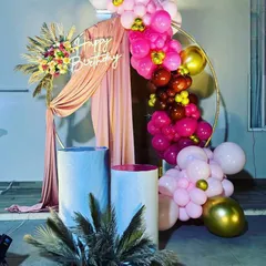A beautiful circular backdrop with pink drapes and a vibrant balloon arrangement. This setup combines soft fabrics with bright balloons for a sophisticated and celebratory look.