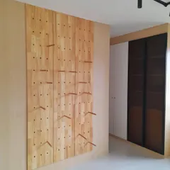 The perforated pine wood display system brought to life. This custom feature provides a unique and adaptable way to store and showcase everything from bags and clothes to sports equipment.