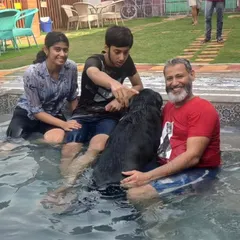 A father and his kids sharing a special moment with their black lab in the pool. These are the memories we love to help create.