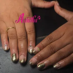 Perfect for a reception or festive event, these nail extensions feature a dramatic gold glitter fade over a neutral base, with a single rhinestone accent for extra sparkle.