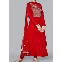 This is a classic red Anarkali suit I tailored for a festive look. It features a long-sleeved design with an intricately embroidered yoke and a flowing skirt, creating a regal and timeless silhouette.