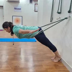 This posture demonstrates how ropes can be used to build core strength. By leaning against the ropes, the student can hold a perfect plank, engaging the abdominal muscles without straining the wrists or shoulders.