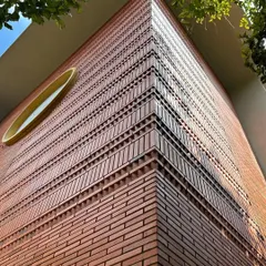 An upward view of the detailed brickwork on a building corner. We use intricate patterns and textures in our brick facades to create visual interest and celebrate the beauty of the material itself.