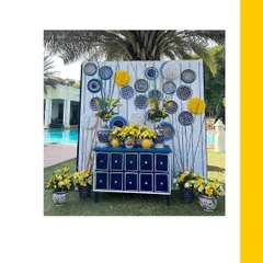 This Blue Pottery themed photo booth was a huge hit. I used a custom-printed backdrop, a blue console table, and an array of blue and white pottery filled with yellow flowers.