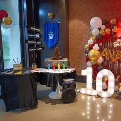 We transform any space into a wizard's workshop. This setup for a 10th birthday includes a sorting hat station, house banners, and a backdrop for a truly immersive experience.