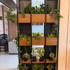 Plants can be beautiful and functional. For this home, I designed a custom metal and wood partition that acts as a living divider. It separates the space while keeping it open and airy, filled with a variety of easy-care indoor plants that clean the air.