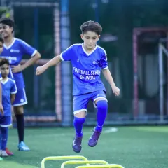 Building agility and coordination from a young age. A young player works on his footwork with agility hurdles during a grassroots training session.