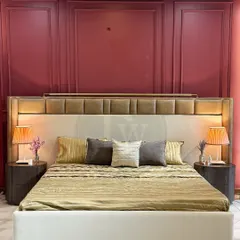 We love playing with color and texture. This bed features a two-tone upholstered headboard set against a bold, paneled wall. The design is both grand and inviting, creating a truly royal feel.