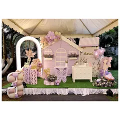 Welcome to a fairy's dream home. This enchanting setup for a third birthday features a life-sized pastel purple playhouse, a custom butterfly-shaped table, and a glowing number '3' filled with balloons, creating a magical atmosphere for the little ones.