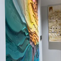 A side profile of the abstract wave mural, emphasizing its 3D nature. The layers are sculpted to create real shadows and depth, an effect that changes with the light.