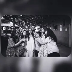 A fun, candid black and white group photo of a family playfully interacting. Monochrome helps focus on the expressions and the story being told.