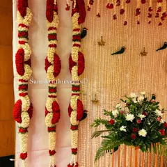 A close-up of our intricate floral hangings. These garlands are made by weaving together jasmine and red rose petals into unique patterns, showcasing our attention to detail.