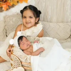 One month old and already so loved. Including older siblings in newborn milestone shoots creates such precious memories, like this sweet moment with big sister smiling for the camera.