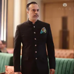 Our founder, Manu Arya, wearing a classic black bandhgala suit. The fit is impeccable, and the look is elevated with a colorful pocket square for a personal touch.