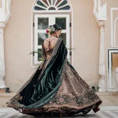 A full-length shot of the bride in a magnificent velvet lehenga, twirling in the courtyard of Chomu Palace, Jaipur.