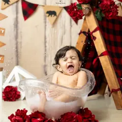 A big, dramatic splash and a funny face make this camping-themed milk bath photo a truly memorable one.