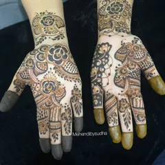 A stunning example of Indo-Arabic mehendi. This design features bold, dark floral motifs combined with delicate, detailed patterns, creating a beautiful contrast on the hands.