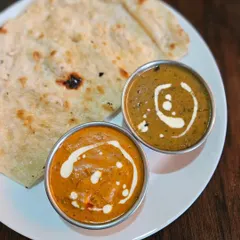 A classic comfort meal: Paneer Butter Masala and our signature Dal Makhani, served with hot butter fulkas. This is the kind of food that warms your soul.
