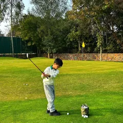 A junior golfer practices his swing on the chipping green. Our programs are designed to build strong fundamentals from a young age.