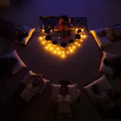 An overhead view of a group sound bath shows participants arranged in a circle, fostering a sense of community and shared peace. The singing bowls are placed centrally to ensure the sound envelops everyone equally.