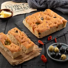I wanted to show both the whole focaccia bread and a single serving to give customers a complete picture. The ingredients like olives and peppers are scattered around to highlight the flavor.