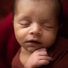 A simple, peaceful close-up of a newborn's face. I use soft lighting to highlight their perfect features, from their eyelashes to their tiny lips.