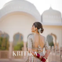 A stunning bridal portrait from behind, showcasing the intricate details of the lehenga and hairstyle against the backdrop of The Jaibagh Palace in Jaipur.