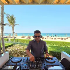 A daytime beach event requires a completely different energy. Here I am at a sundowner in Dubai, curating a relaxed yet groovy playlist as the sun sets over the ocean. It's all about matching the music to the mood.