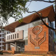 The exterior of the Nirbhaya Centre in Bangalore, featuring a distinctive brick mural and a welcoming entrance shaded by a 100-year-old raintree.