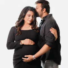 A sweet and tender moment captured in the studio, with the partner gently kissing the mom-to-be's forehead. This pose highlights the protective and loving bond between them.