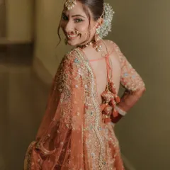 A smile that lights up the room. This over-the-shoulder shot of Muskan captures her happy and radiant personality, along with the beautiful back details of her bridal blouse.