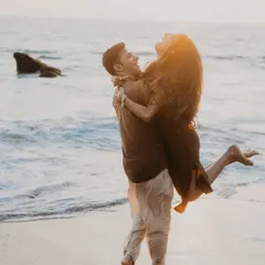 A joyful, candid moment of the couple laughing and playing in the waves. This photo perfectly captures the fun and carefree spirit of a beach pre-wedding shoot.