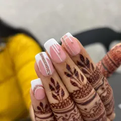 A beautiful bridal nail set. These square-shaped extensions feature a modern white French design accented with delicate lines of silver glitter, perfectly complementing the intricate henna design.