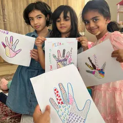 High fives for creativity! These girls are showing off the colorful and intricate patterns they used to decorate their hand drawings.
