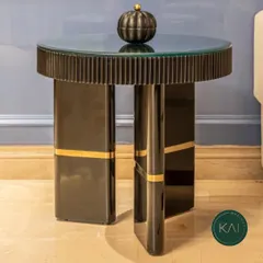 This modern side table features a fluted base with a high-gloss black finish and gold accents, topped with glass. It's a perfect example of our ability to create small but impactful pieces that exude luxury.