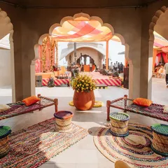 A cozy seating nook with traditional 'charpai' beds and colorful woven stools ('moodas'). This setup for the 'Jaipur Wali Haldi' was designed to evoke a sense of nostalgia and rustic charm.
